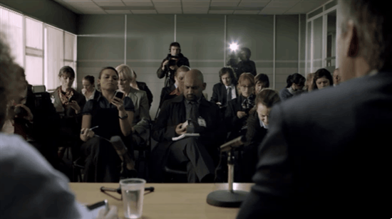 GIF taken from an episode of BBC's Sherlock - everyone at a press conference receives a text (from Sherlock) which reads 